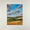 clouds in a blue sky across green and golden fields, acrylic on canvas board